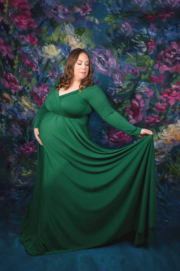 Pregnant Mom posing in a green dress during her studio maternity photoshoot