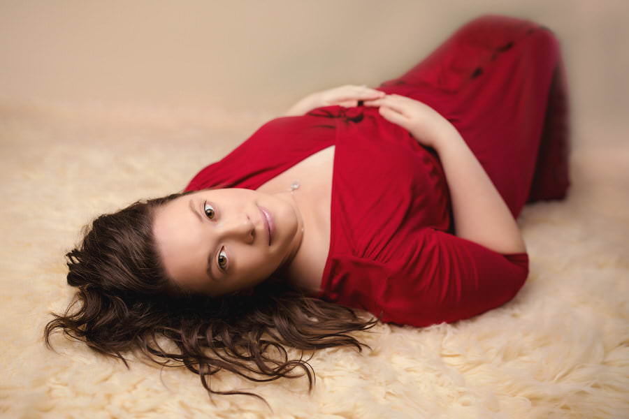 Pregnant Mom in red dress posing for her maternity photography session