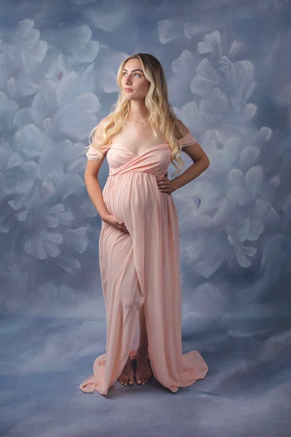 Pregnant Mom posing in a pink dress during her studio maternity photography session