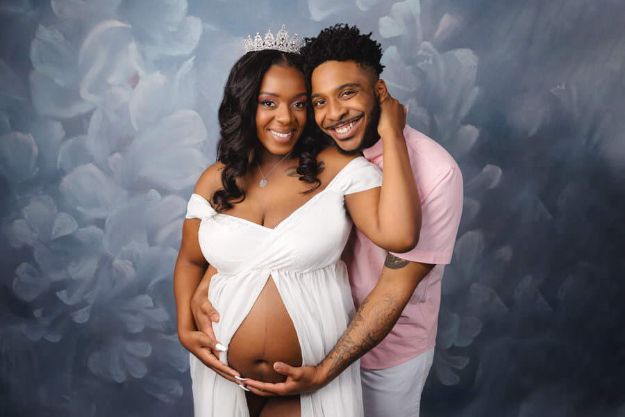 Smiling couple posing in studio during their maternity photoshoot