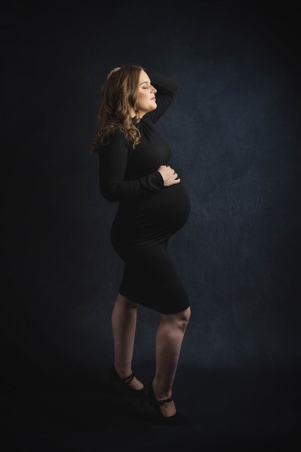 Pregnant Mom posing in a black dress during her studio maternity portrait session