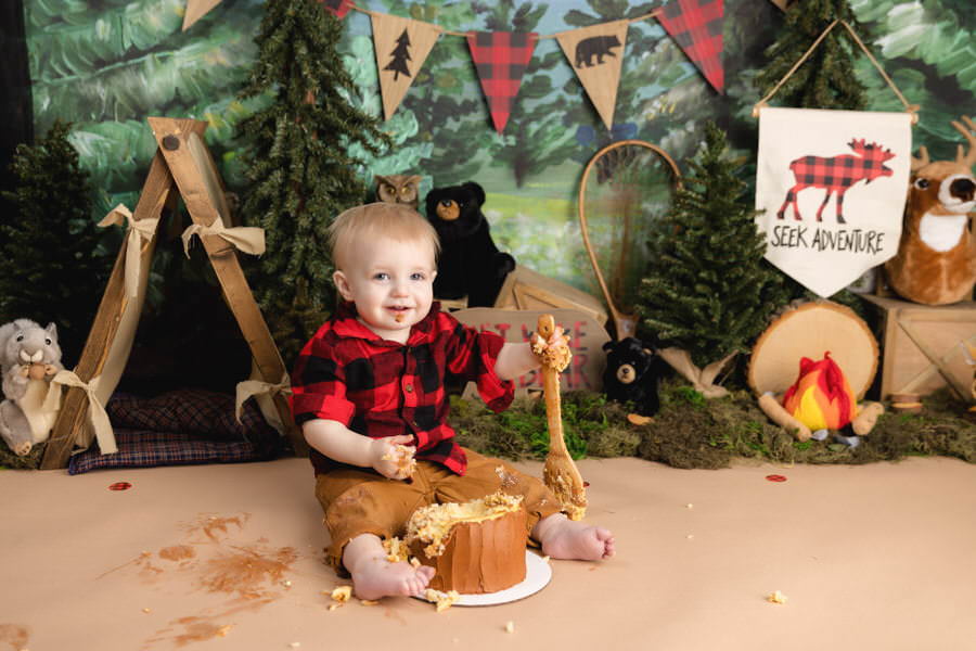 Lumberjack themed cake smash photoshoot with a smiling baby boy
