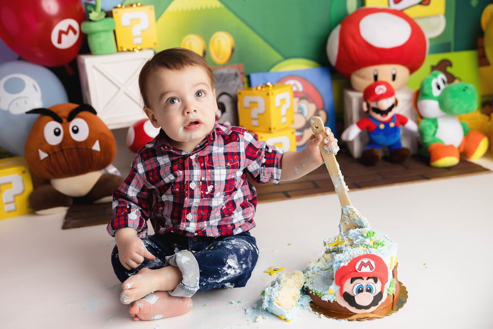 Baby boy looking at the camera during his Super Mario cake smash photoshoot