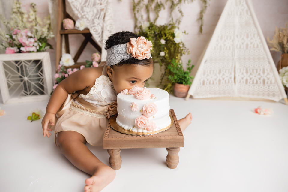 Boho themed cake smash photoshoot with baby girl eating cake