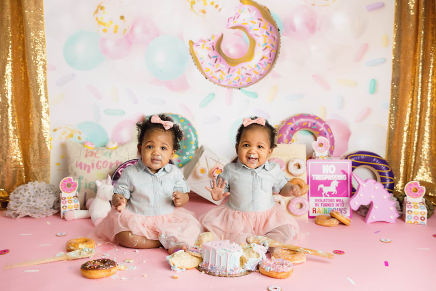 Twins deciding between cake and donuts during their cake smash photography session