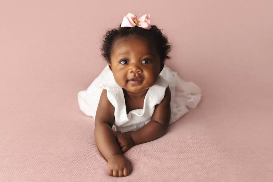 Wide eyed infant girl posing for her baby photography session