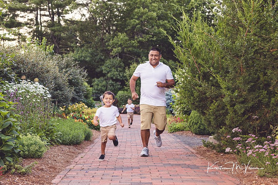 Hispanic Dad running with his 2 sons down the sidewalk during their family photoshoot with The Flash Lady Photography