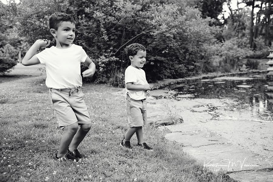 Black and white photo of 2 hispanic brothers throwing rock during their family photoshoot