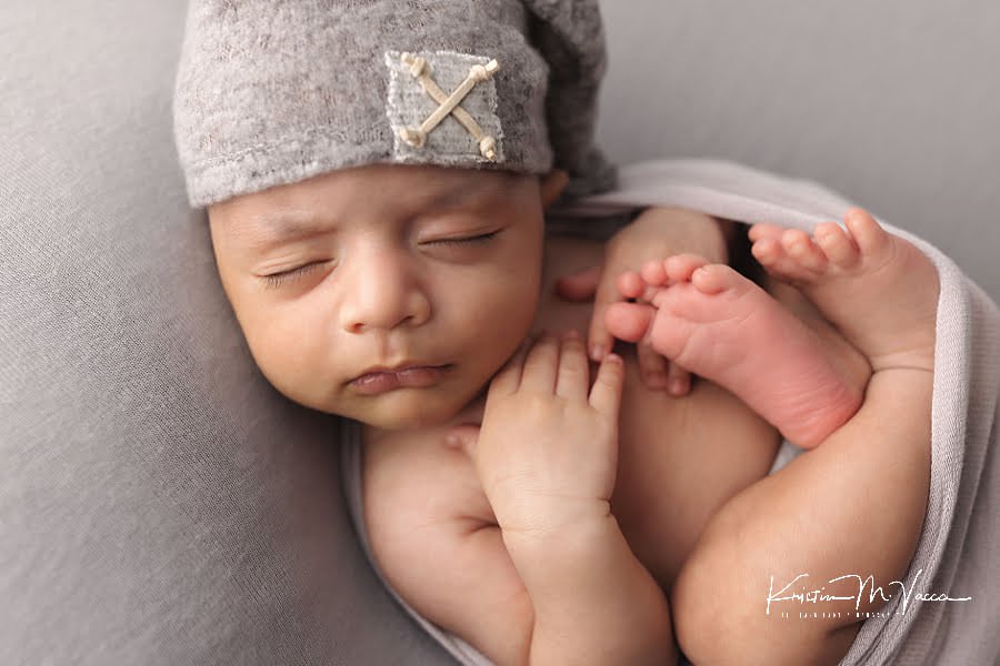 Baby boy in a gray hat sleeping during his 6 week old newborn photoshoot