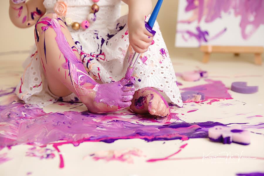 Close up of a Toddler girl's feet in purple and pink during her paint smash photoshoot