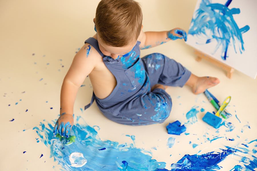 Above shot of a toddler boy painting the floor during his birthday photoshoot