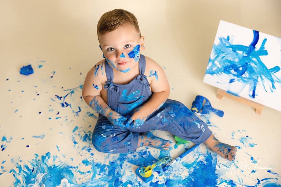 Above shot of a toddler boy covered in paint during his blue paint smash