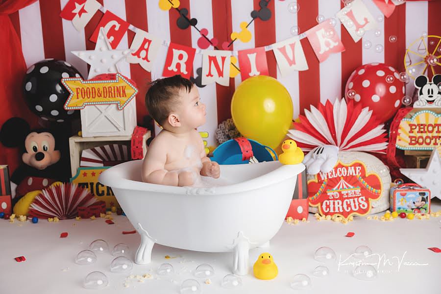Baby boy cleans off in a tub bath during his birthday photoshoot