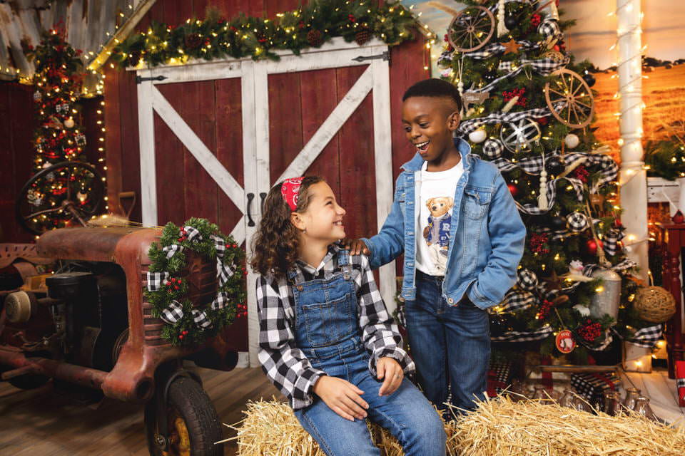 Young boy and girl laughing together during their Christmas photoshoot