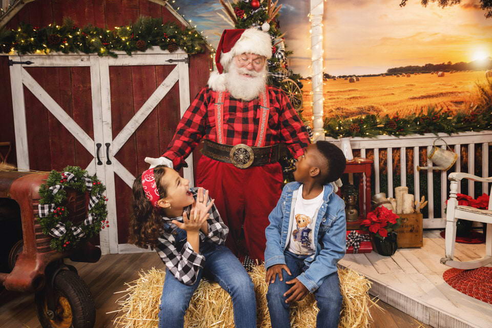 Young boy and girl surprised during their farmhouse Christmas photos with Santa