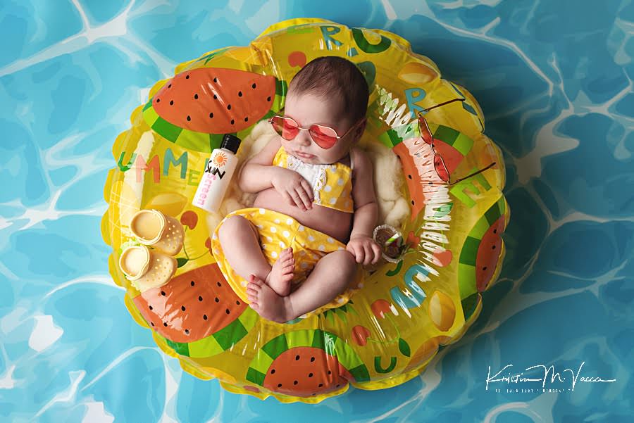 Baby girl in a yellow bathing suit sleeping in a pool floatie during her summer newborn photos