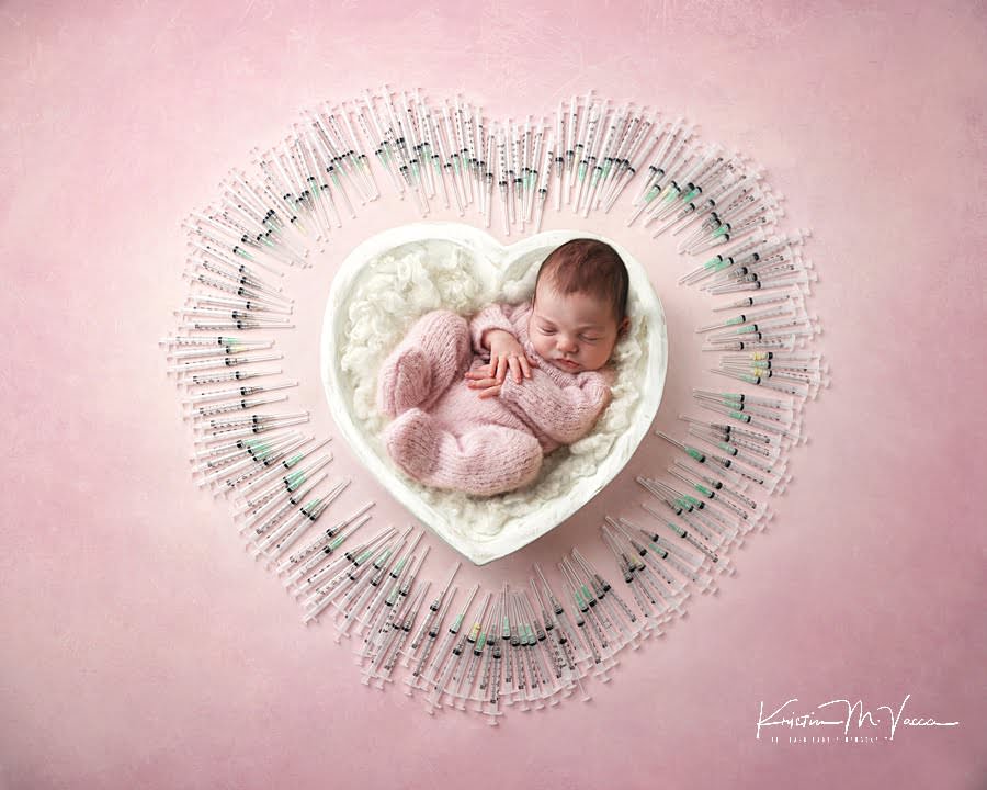 Baby girl in pink pjs in a white heart bowl surround by IVF needles during her summer newborn photos