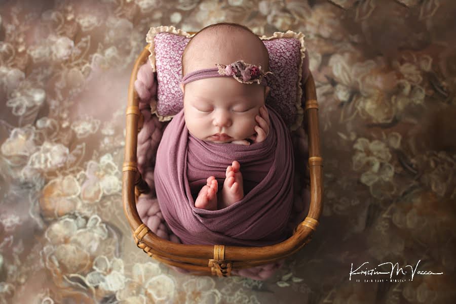 Sleeping baby wrapped in purple during her pretty in pink newborn photos