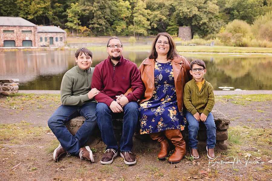 Posed early fall family photos sitting on a bench smiling