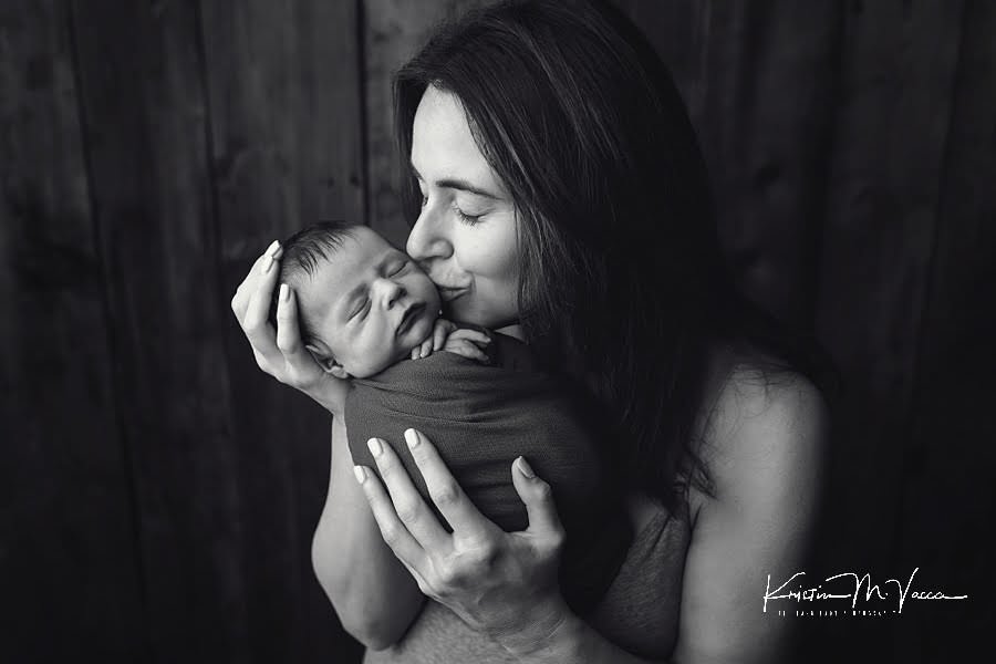 Black and white photo of Mom kissing her baby boy during their photoshoot