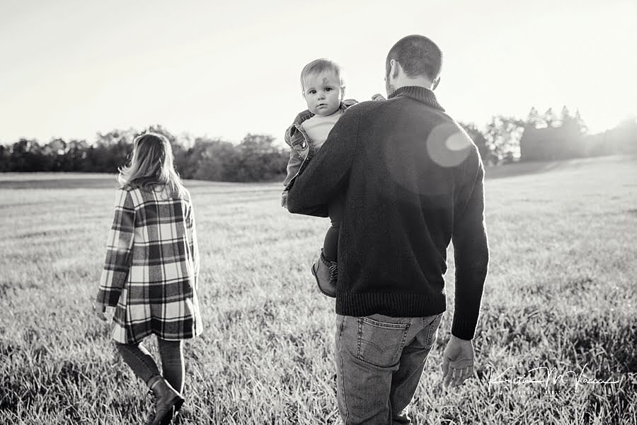 Black and white photo of a family walking in a field during their family photos