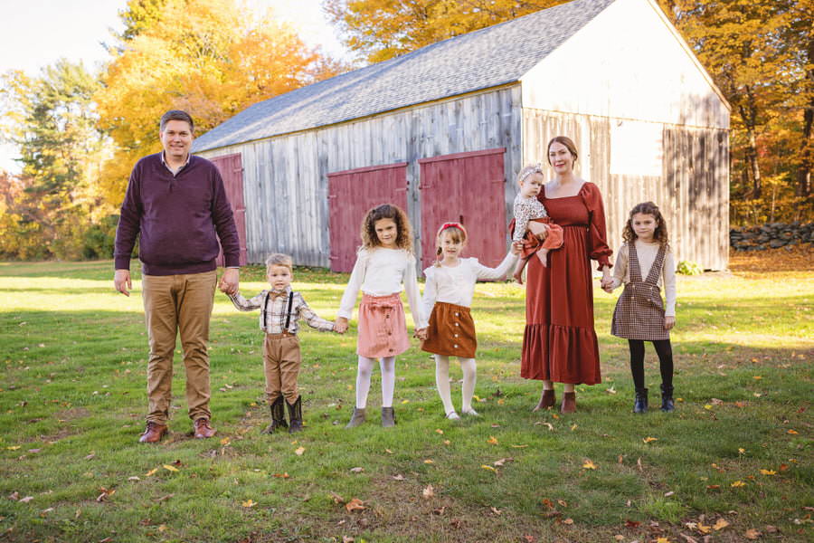 Family of 7 standing together holding hands during their photoshoot