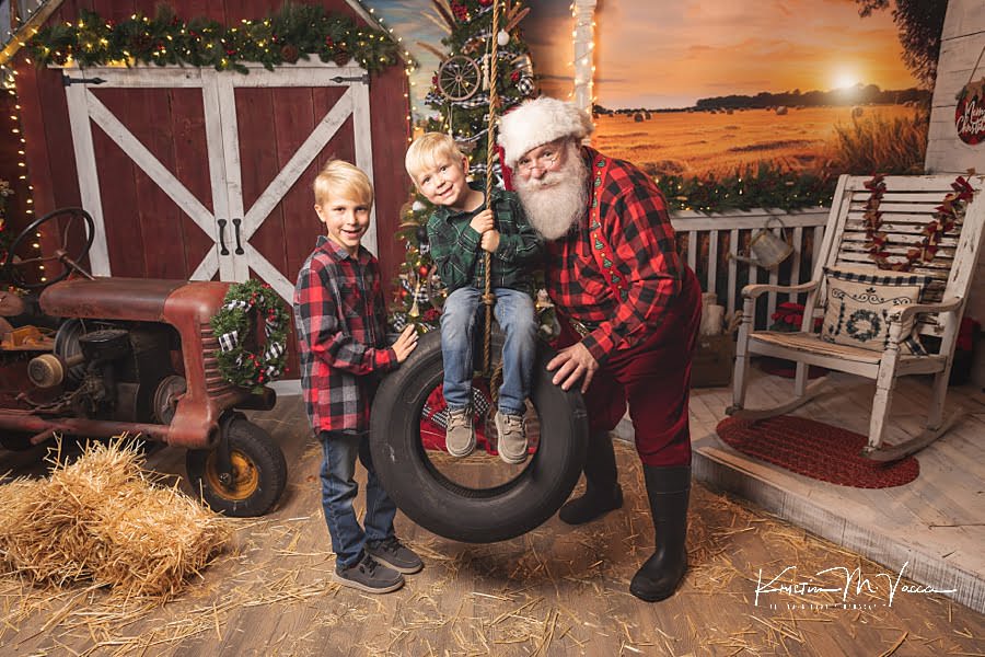 2 brothers have fun with a tire swing with Santa Claus at The Flash Lady Photography