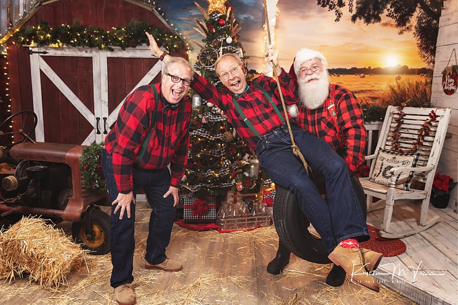 2 husbands enjoy the tire swing with Santa Claus smiling at The Flash Lady Photography