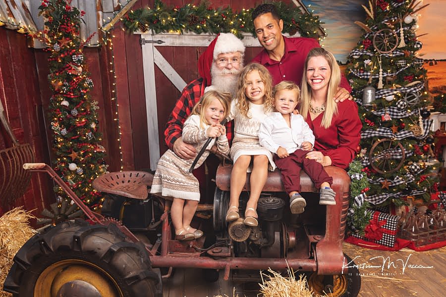 Family of 5 sits with Santa Claus on a tractor during their photoshoot