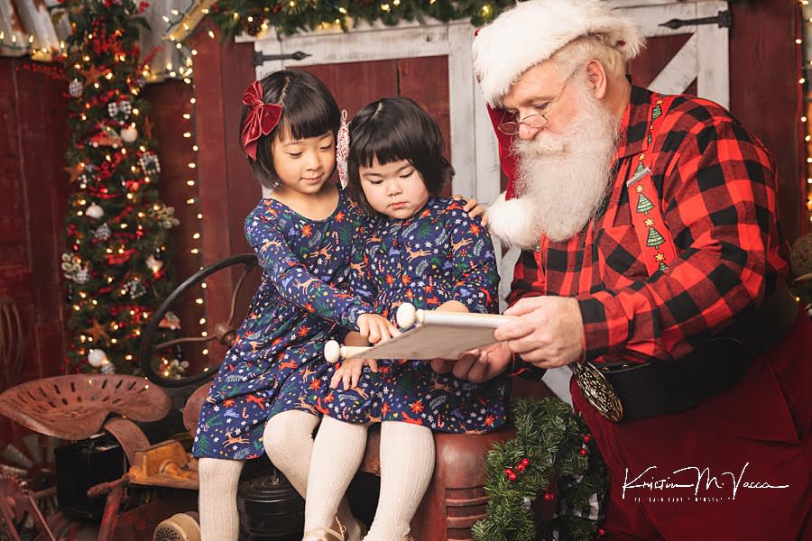 Santa Claus reads with 2 sisters during their Christmas photoshoot
