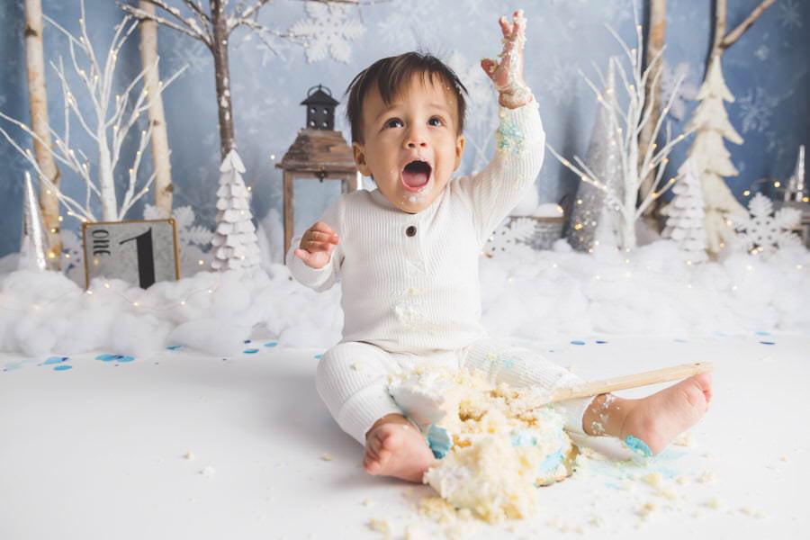 Baby boy excited about his winter cake smash photoshoot